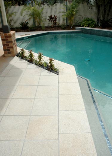 Almond Granite stone tile or pool paver shown in situ with matching coping