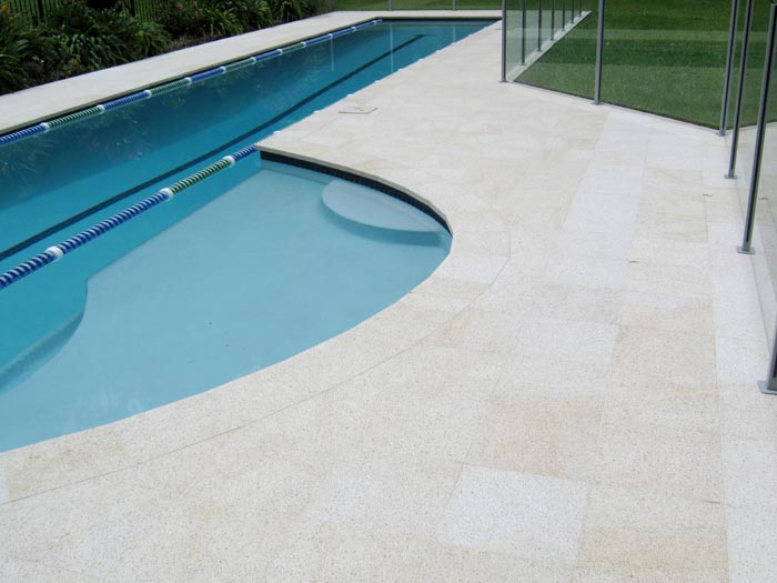 Almond Granite stone tile or pool paver shown in situ with matching coping