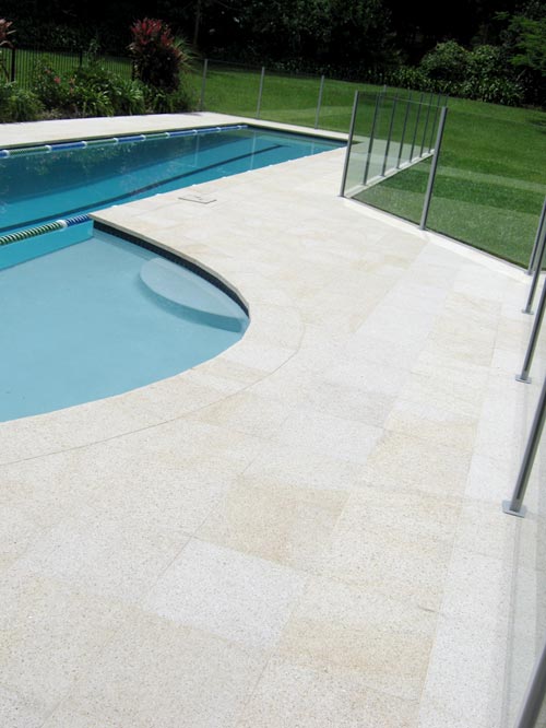 Almond Granite stone tile or pool paver shown in situ with matching coping