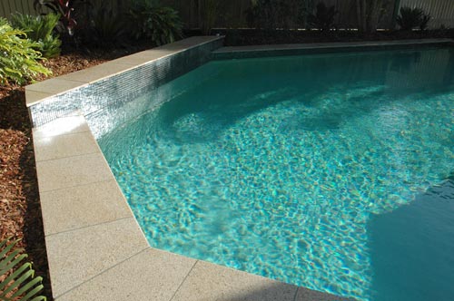 Almond Granite stone tile or pool paver shown in situ with matching coping