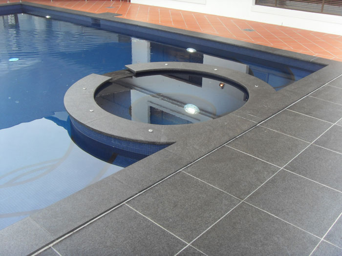 Black Granite stone tile or pool paver shown in situ with matching coping