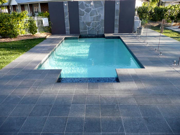 Black Granite stone tile or pool paver shown in situ with matching coping