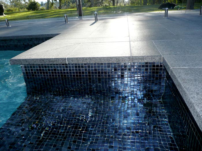 Black Granite stone tile or pool paver shown in situ with matching coping