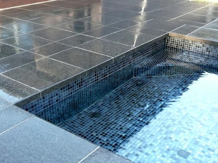 Black Granite stone tile or pool paver shown in situ with matching coping