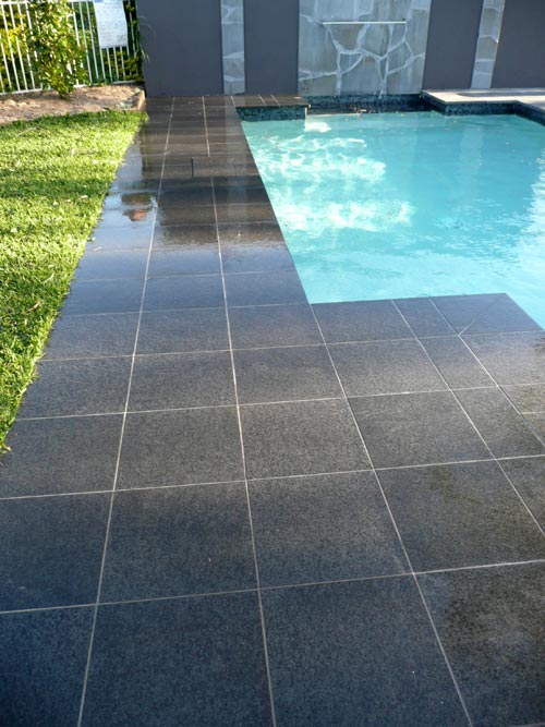 Black Granite stone tile or pool paver shown in situ with matching coping