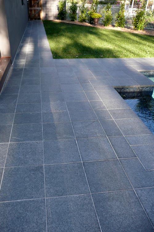 Black Granite stone tile or pool paver shown in situ with matching coping