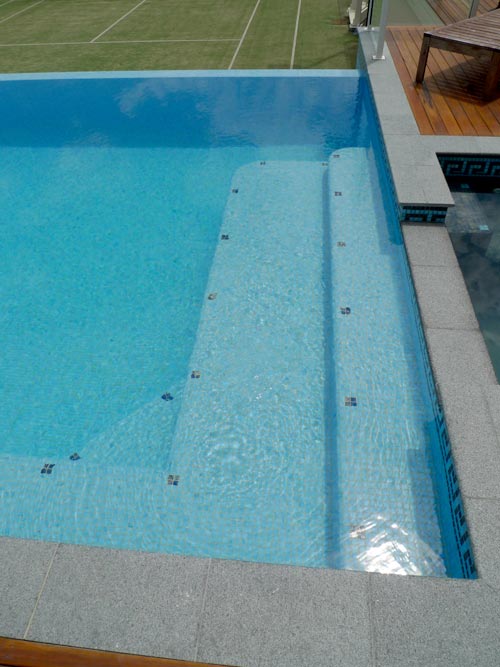 Dark Grey Granite stone tile or pool paver shown in situ with matching coping