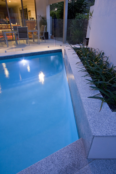 Light Grey Granite stone tile or pool paver shown in situ with matching coping