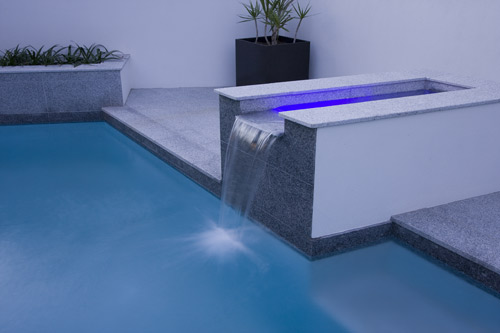 Light Grey Granite stone tile or pool paver shown in situ with matching coping