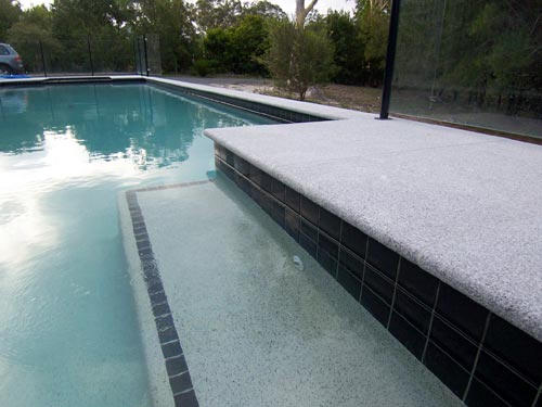 Light Grey Granite stone tile or pool paver shown in situ with matching coping