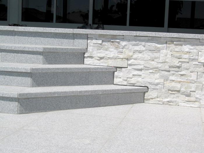 Closeup of Light Grey Granite stone tiles shown here being used for steps in a stepped terrace