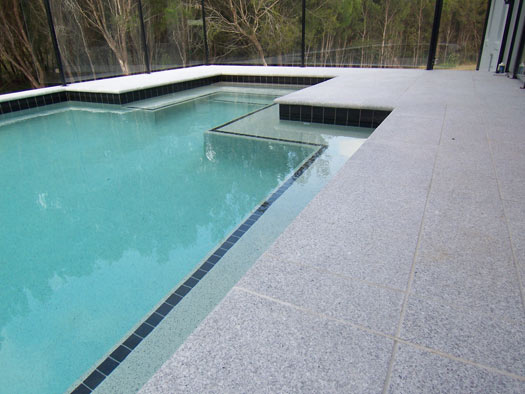 Light Grey Granite stone tile or pool paver shown in situ with matching coping