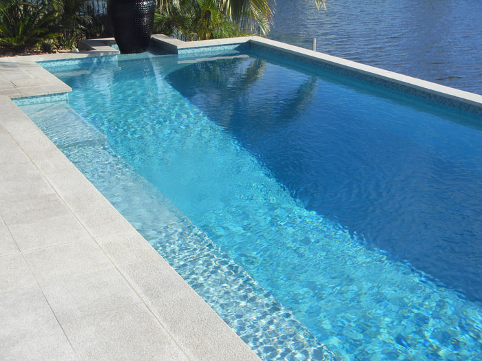 Mushroom Granite Pool stone tile or pool paver shown in situ with matching coping