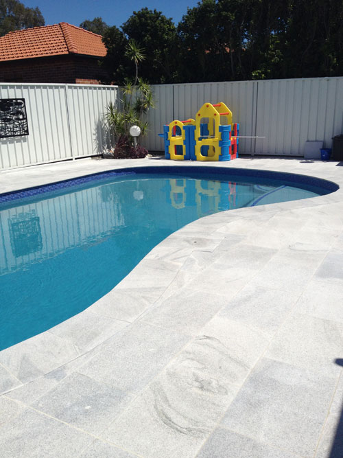 Sandwave Granite stone tile or pool paver shown in situ with matching coping