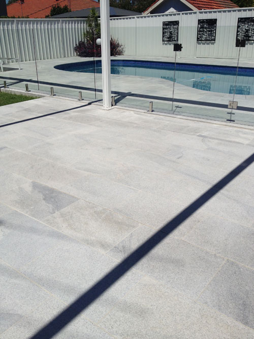 Sandwave Granite stone tile or pool paver shown in situ with matching coping