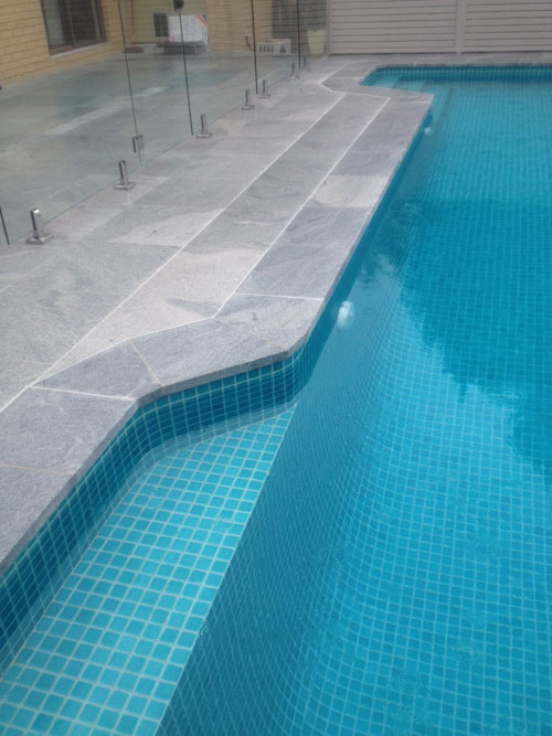 Sandwave Granite stone tile or pool paver shown in situ with matching coping