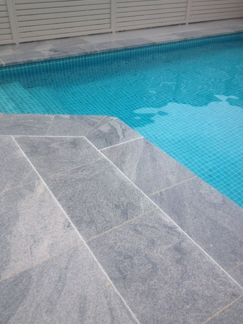 Sandwave Granite stone tile or pool paver shown in situ with matching coping