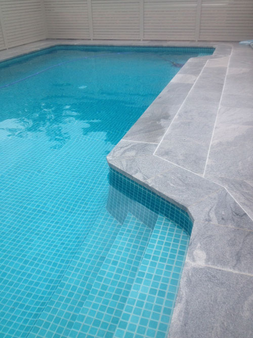 Sandwave Granite stone tile or pool paver shown in situ with matching coping