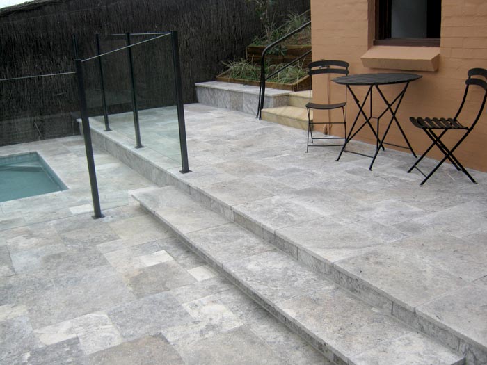 Silver Travertine Tumbled Unfilled stone tile or pool paver shown in situ with matching coping