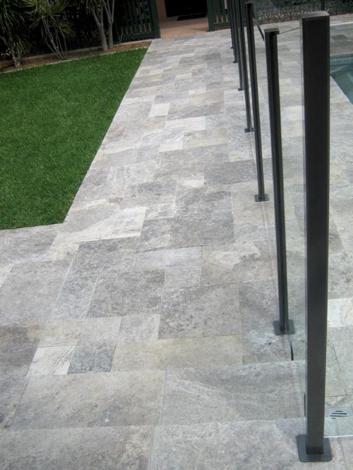 Silver Travertine Tumbled Unfilled stone tile or pool paver shown in situ with matching coping