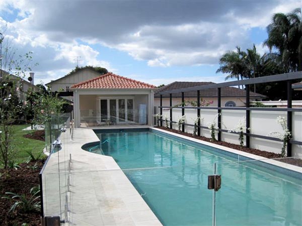 Travertine Linen is a stone tile pictured in place surrounding a swimming pool with matching travertine coping tiles.