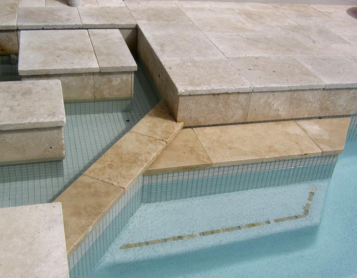 Travertine Linen tumbled unfilled stone tiles and coping around swimming pool