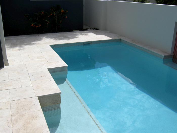 Travertine Linen tumbled unfilled stone tiles and coping around swimming pool