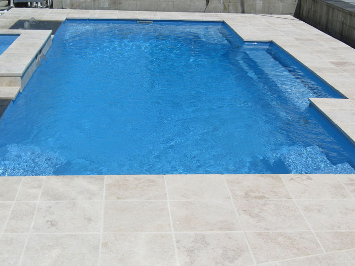 Travertine Linen stone tiles and coping around swimming pool and spa pool