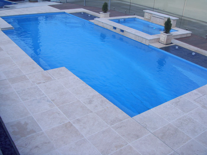 Travertine Linen stone tiles and coping around swimming pool and spa pool