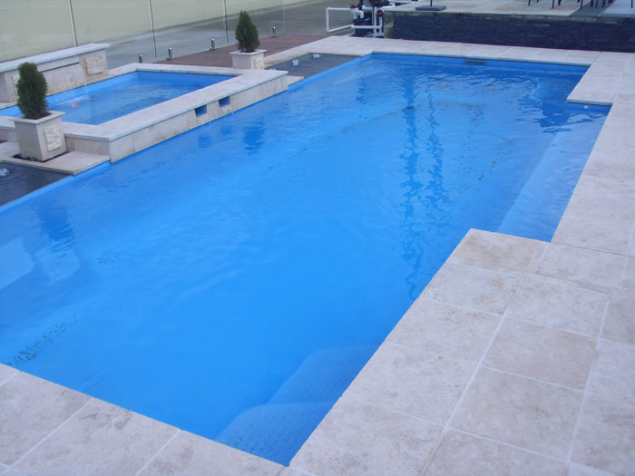 Travertine Linen stone tiles and coping around swimming pool and spa pool