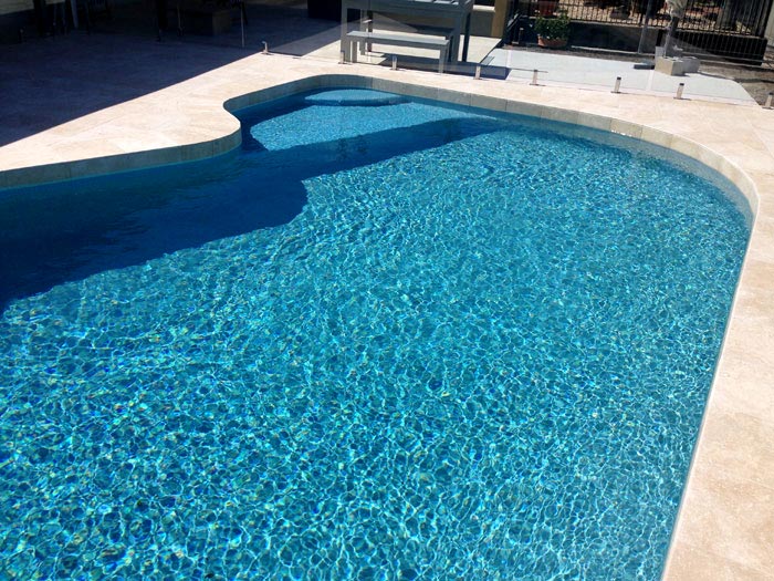 Travertine Linen stone tiles and coping around swimming pool