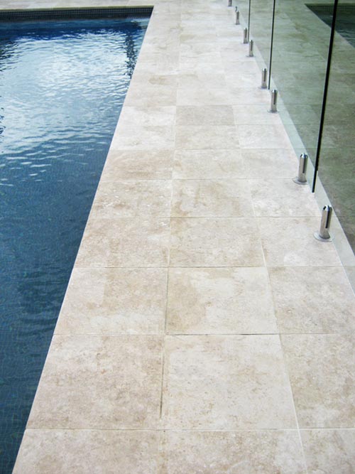 Travertine Linen stone tiles and coping around swimming pool