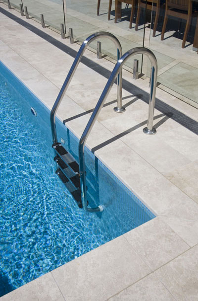 Closeup of our Travertine Linen natural stone pool tiles and coping