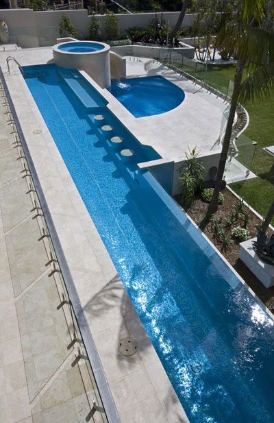 Travertine Linen natural stone tiles  being used for pool tiling and coping around this swimming pool with spa and swim up bar and adjoining wading pool