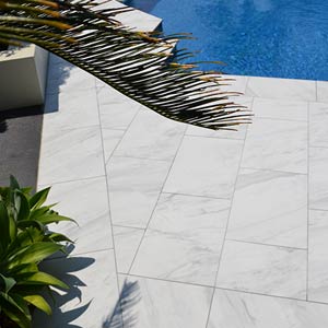Carrara Marblano® tiles shown around a pool