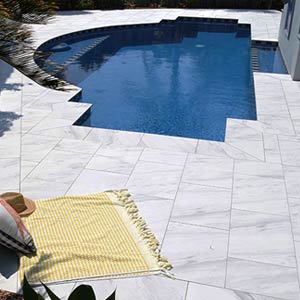 Carrara Marblano® tiles shown around a pool