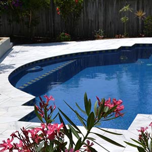 Carrara Marblano® tiles shown around a pool