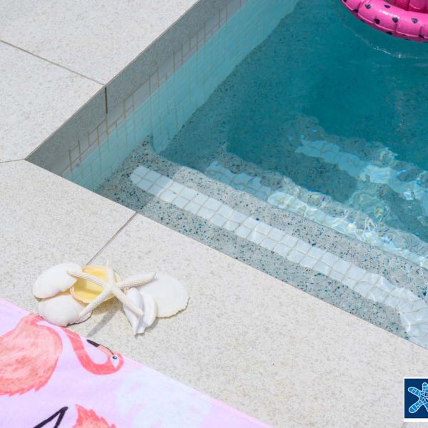 Coconut Drift Porcelain Dropface pool coping with Urban White waterline and White step marker tiles